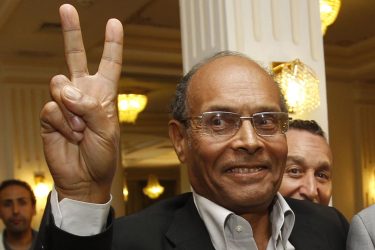 Tunisia's interim President Moncef Marzouki flashes a victory sign during a news conference after attending a meeting to finalize the transition in Tunis November 21, 2011. Tunisia's Islamist Ennahda party will keep the country's ministers of defence and finance and the central bank governor in their posts when it announces a new government, a senior coalition source told Reuters on Monday. REUTERS/Zoubeir Souissi (TUNISIA - Tags: POLITICS)